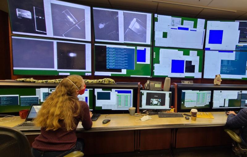 Two scientists in a control room full of computer monitors that allow them to adjust diamond mirrors in their CBXFEL experiment