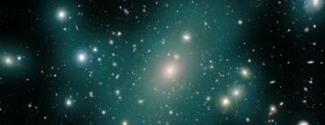 A smattering of hundreds of galaxies of different shapes and sizes against a black background, Semi-opaque teal blobs surround and connect many of the galaxies.