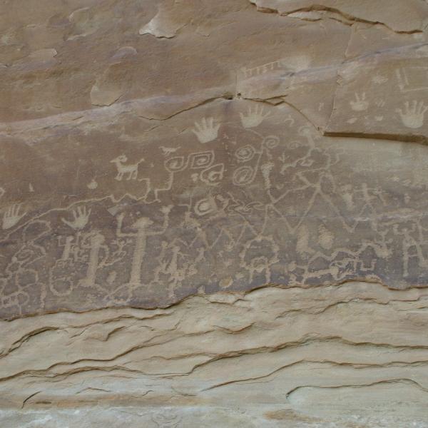 Rock art featuring human and animal forms and handprints