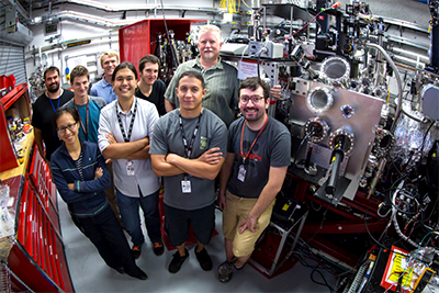 photo: researchers posing with laser equipment