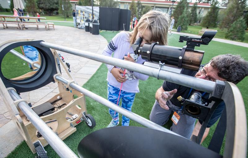 Visitors at KIPAC are observing the sun through telescopes and sun-spotters.