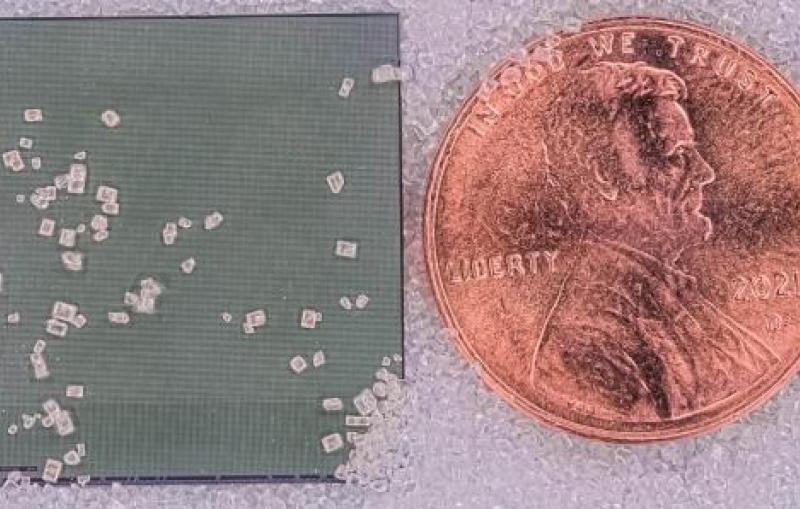 Silicon chip that integrates both imaging sensors and data compression, shown next to a U.S. penny