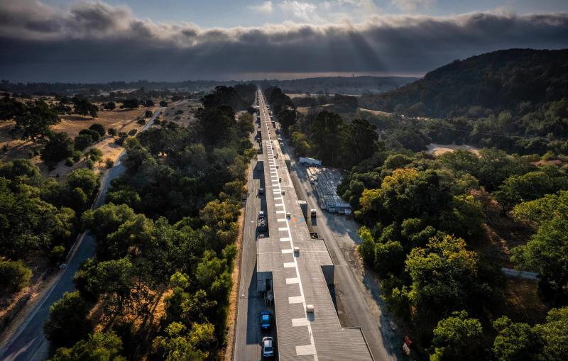 A narrow two-mile long building stretches through trees and foothills.