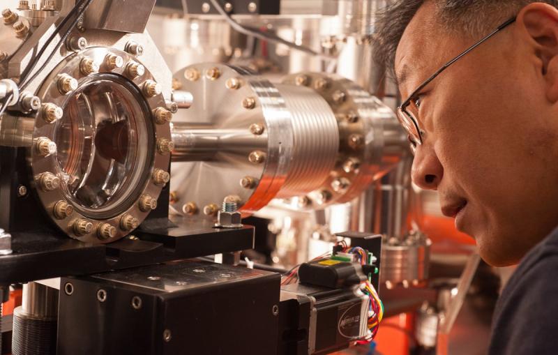 Yiping Feng examines a chamber at LCLS' Front End Enclosure