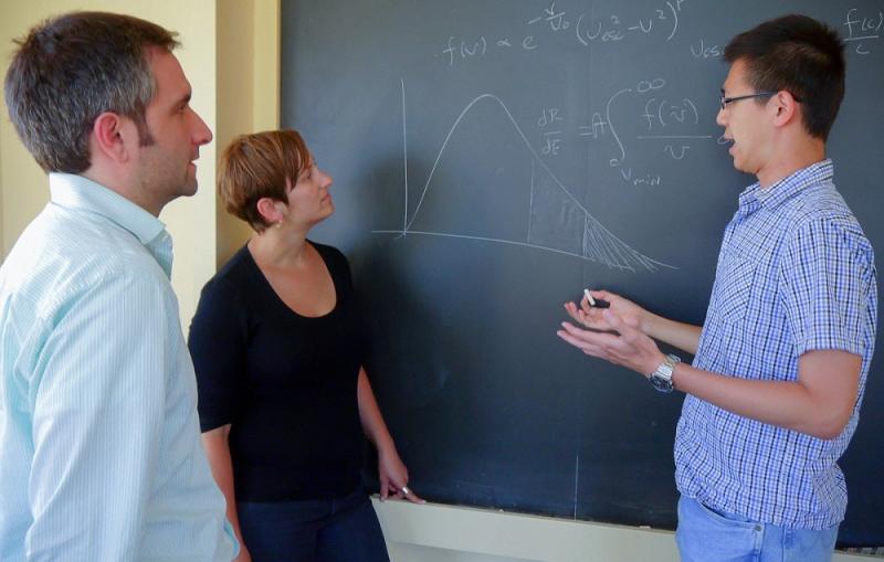 KIPAC theorists (l to r) Louis Strigari, Risa Wechsler and Yao-Yuan Mao discussing dark matter velocity distributions. (Credit: Luis Fernandez.)
