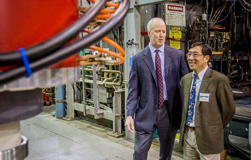 CPI President and Chief Operating Officer Robert A. Fickett, left, and SLAC Lab Director Chi-Chang Kao look at one of the XL5 klystrons the company built under a cooperative agreement with SLAC. 
