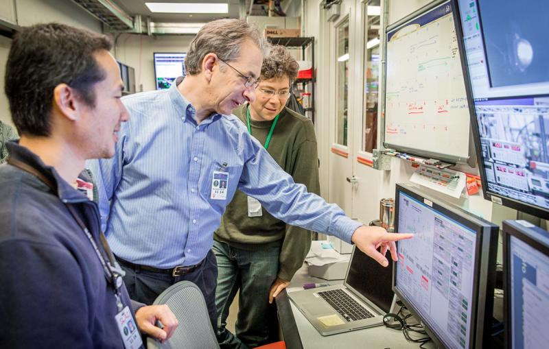 Photo - Nicholas Sauter, middle, points to a monitor during an experiment this month at SLAC's Linac Coherent Light Source X-ray laser.