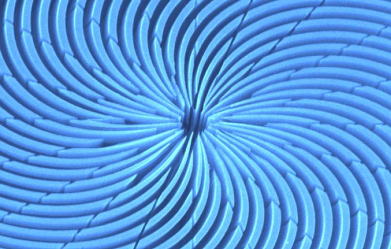 Image - This colorized scanning electron microscope image shows a top-down view of a spiral zone plate, an X-ray optical device, created using a chemical etching technique developed at SLAC. (Chieh Chang, Anne Sakdinawat)