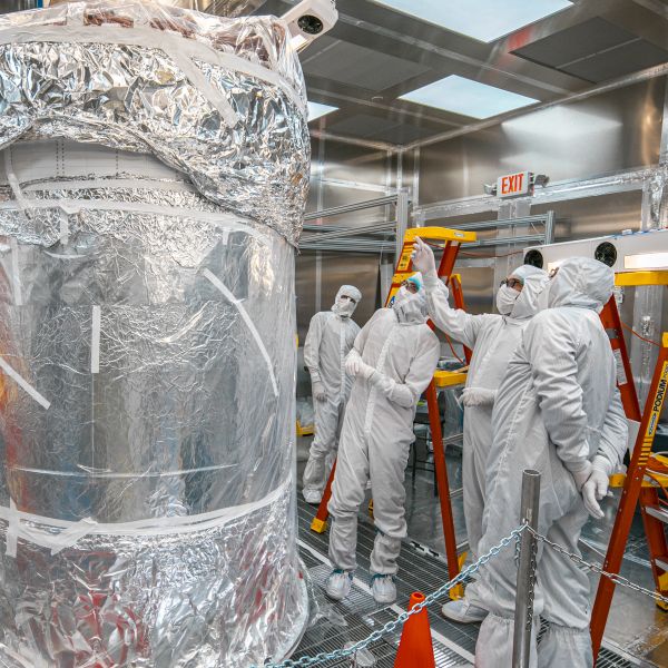 Researchers assess LZ’s central detector while it is wrapped in foil.