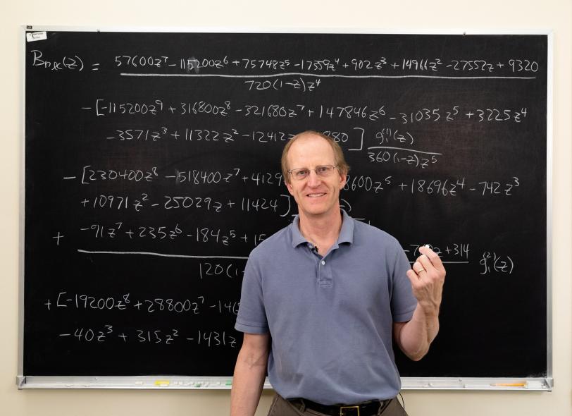 A man standing in front of a chalkboard.