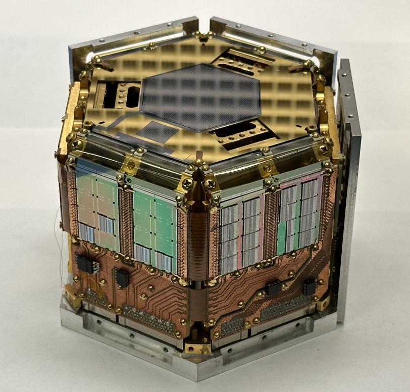 a hexagonal, copper and gold-colored experimental apparatus.