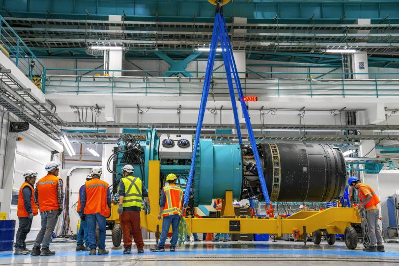 A black tube mounted to an aqua blue apparatus is prepped for lifting.