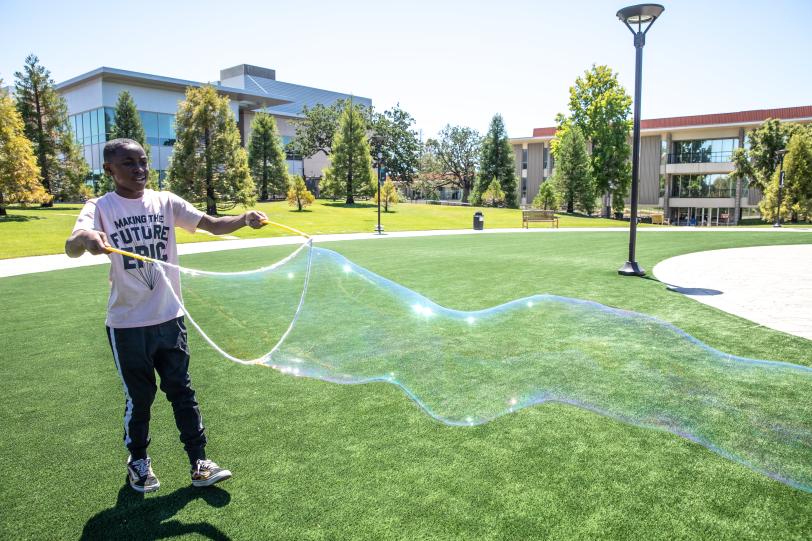 Student at the CORE Science Institute creates a giant bubble.