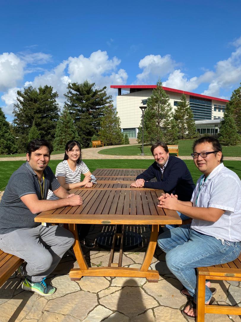 Four members of the SLAC MicroBooNE sit at a picnic table