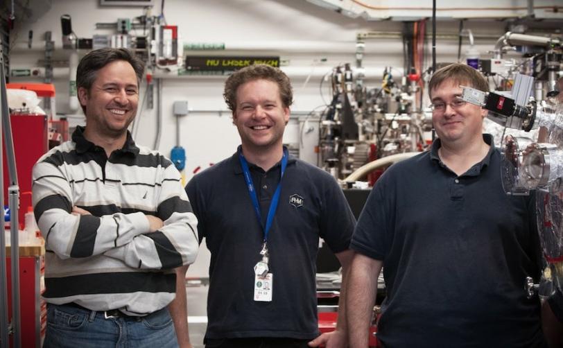 Photo - Three SLAC scientists surrounded by scientific instruments.