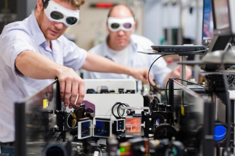 Photo - Two laser specialists wearing goggles, adjust...