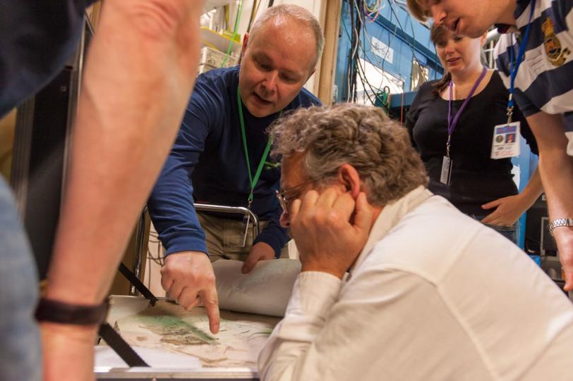 Image - Phil Manning, from left, Pete Larson, Victoria Egerton, and Arjen van Veelen view a fossil sample during a visit to SLAC's Stanford Synchrotron Radiation Lightsource last year. (Matt Beardsley/SLAC)