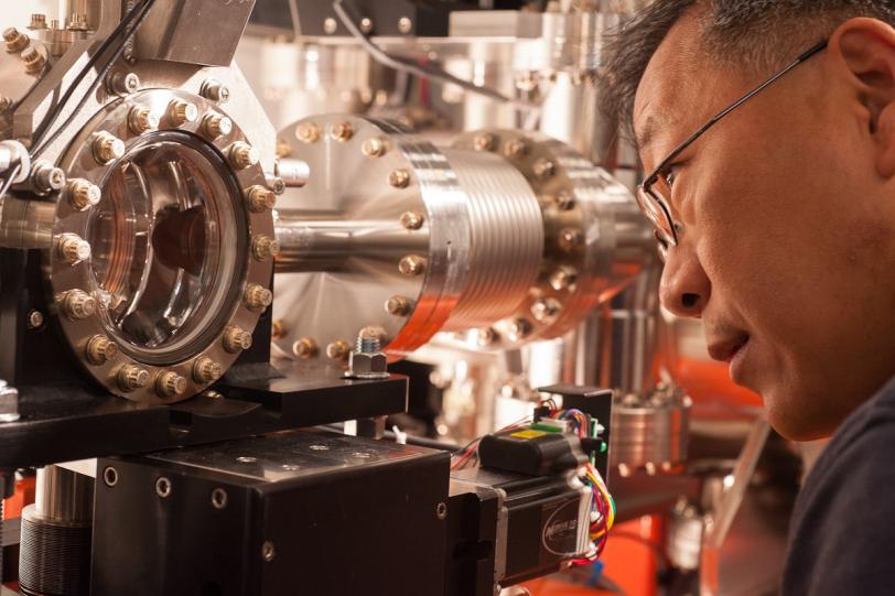 Yiping Feng examines a chamber at LCLS' Front End Enclosure