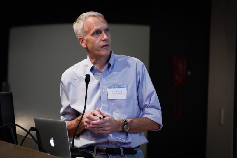Image - Nobel Laureate Brian Kobilka of the Stanford School of Medicine discusses G protein-coupled receptor research during a presentation at the  2014 LCLS/SSRL Users’ Meeting and Workshops. (SLAC National Accelerator Laboratory)