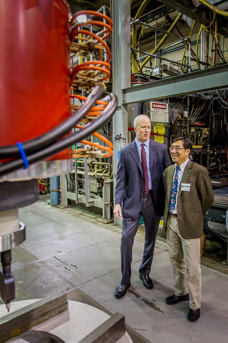CPI President and Chief Operating Officer Robert A. Fickett, left, and SLAC Lab Director Chi-Chang Kao look at one of the XL5 klystrons the company built under a cooperative agreement with SLAC. 