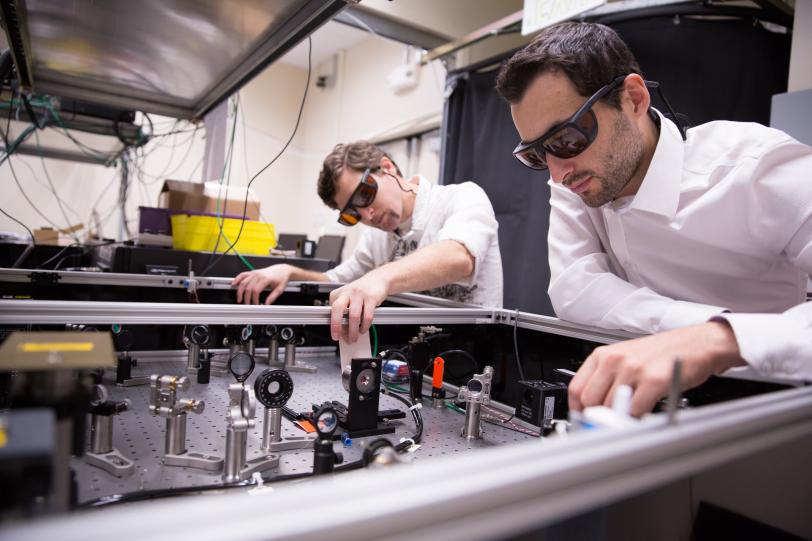 SLAC researchers Michael Litos, left, and Sebastien Corde use a laser table