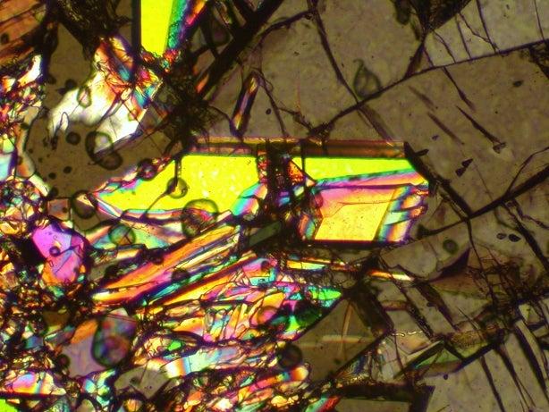 Image - This image shows an illuminated stishovite crystal (yellow). Stishovite is a hard, compressed form of silica that ordinarily appears clear or translucent. Researchers confirmed the rapid transformation of silica to stishovite in a SLAC experiment.