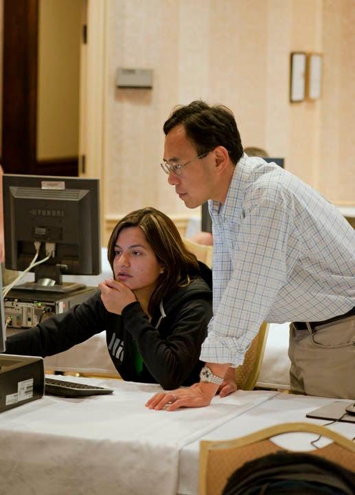 Huang teaches a student at the 2010 U.S. Particle Accelerator School. 