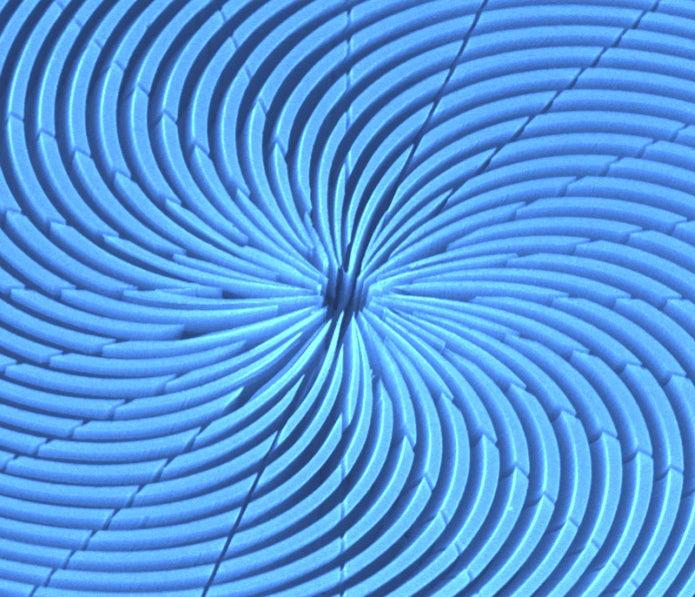 Image - This colorized scanning electron microscope image shows a top-down view of a spiral zone plate, an X-ray optical device, created using a chemical etching technique developed at SLAC. (Chieh Chang, Anne Sakdinawat)
