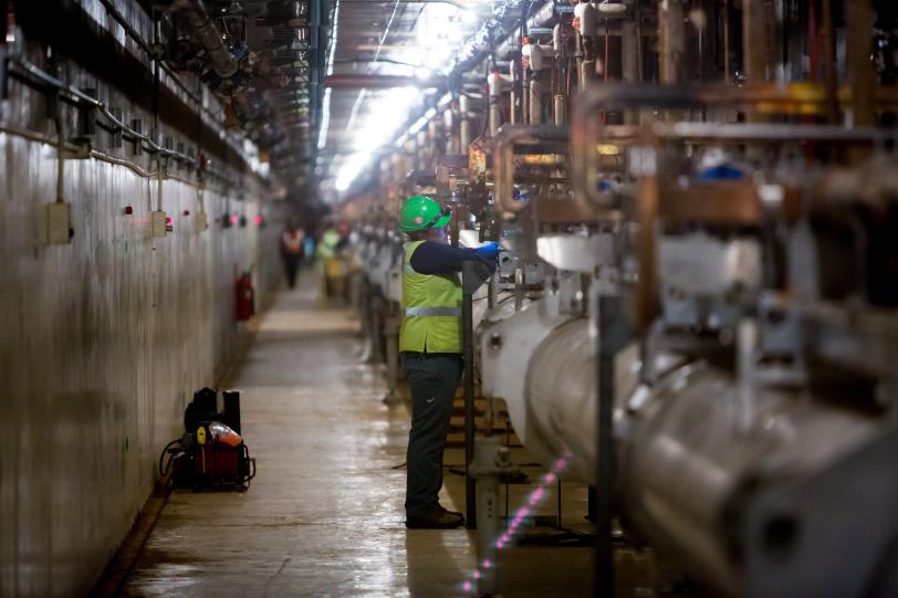 photo - worker starting to disassemble linac