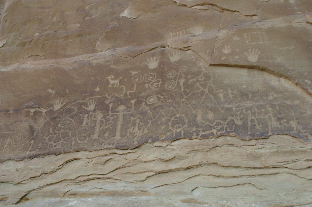 Rock art featuring human and animal forms and handprints