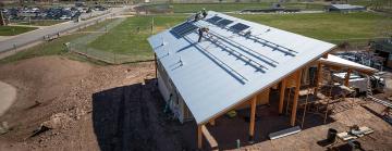 Aerial image of workers installing solar panels on a home.