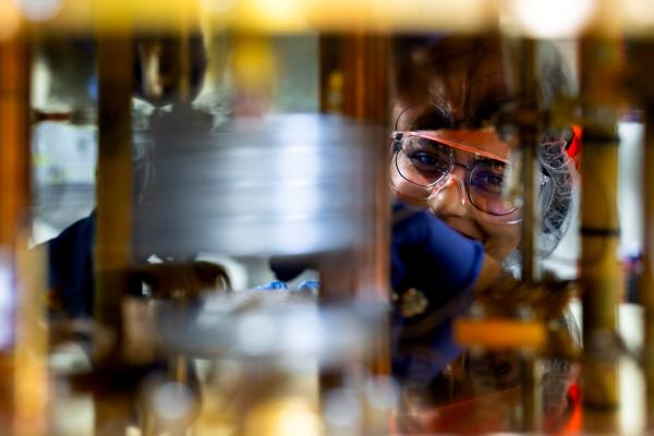Photo of a SuperCDMS collaboration member taking a peek through the dilution fridge during its installation.