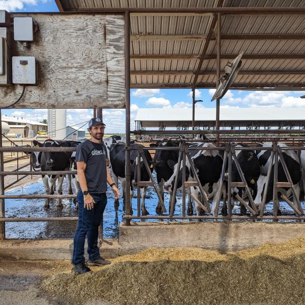 SLAC engineer Gustavo Cezar stands at a dairy farm in Central California.