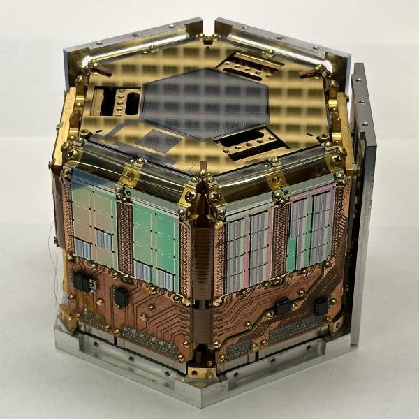 a hexagonal, copper and gold-colored experimental apparatus.